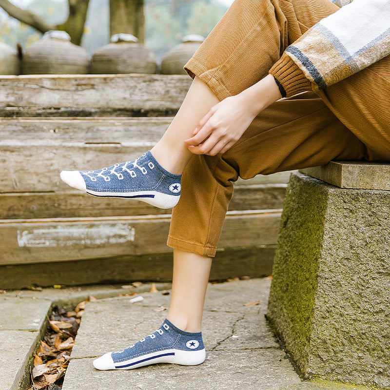 Person wearing blue socks with white soles sitting on stone steps.