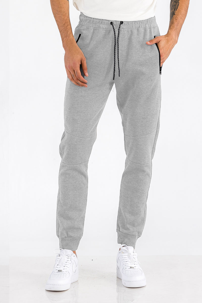 Gray jogger pants worn by a person on a white background