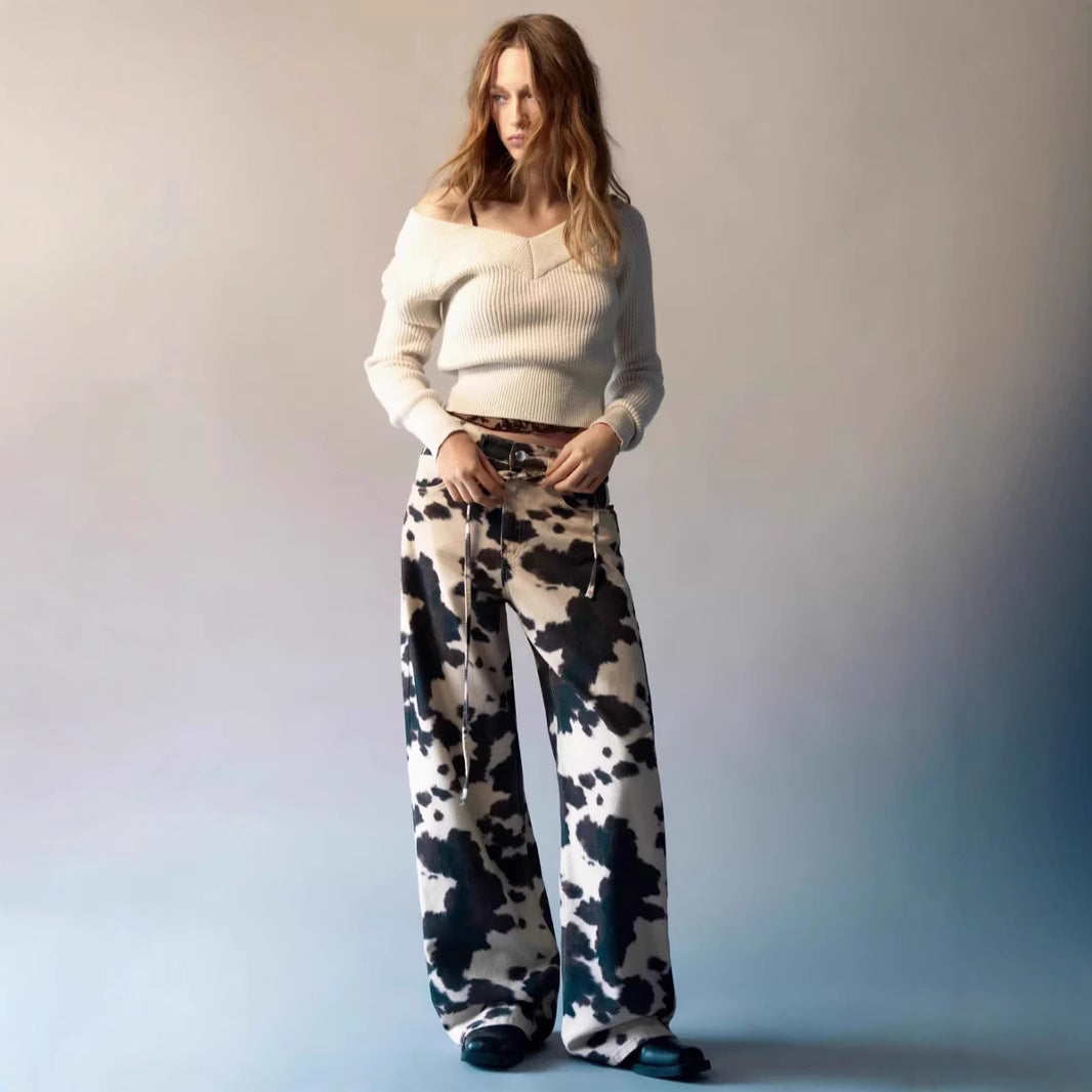 Woman wearing a white sweater and patterned pants against a gradient background