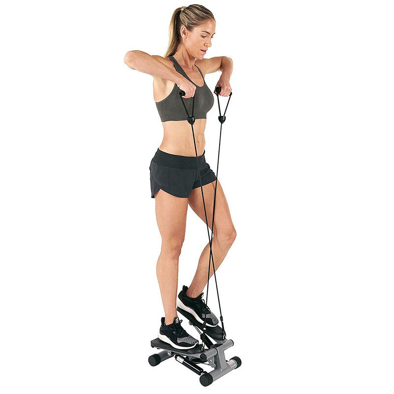 Woman using a step machine with resistance bands on a white background