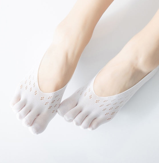 White five-finger socks worn by a person on a light gray background