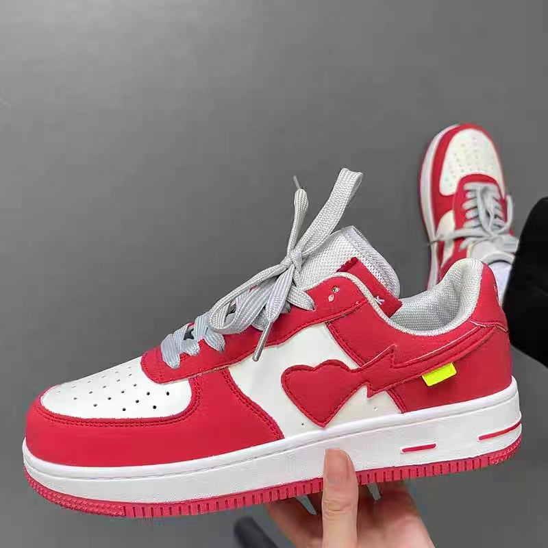 Red and white sneakers with a heart design on a gray background