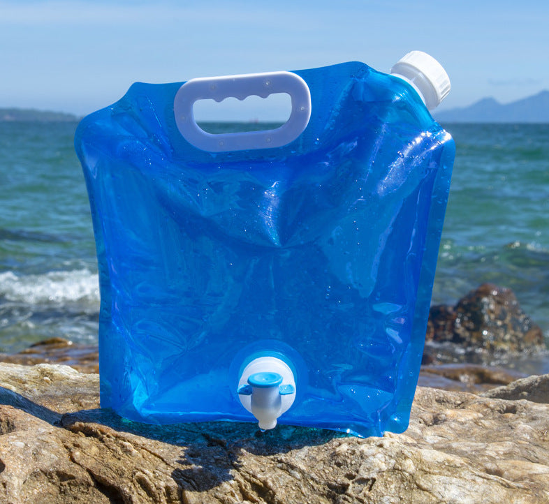 Blue folding water container on a rock with ocean in the background