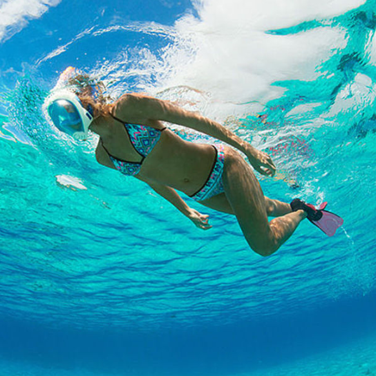 Person snorkeling underwater in clear blue water