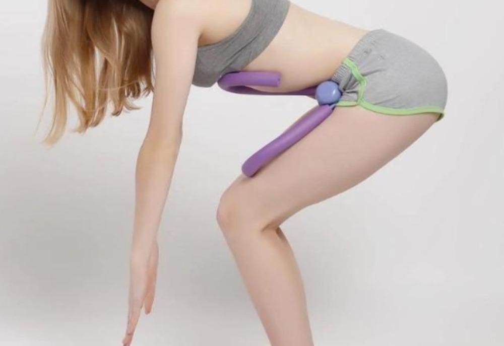 Person using a purple and green tool on their leg against a white background