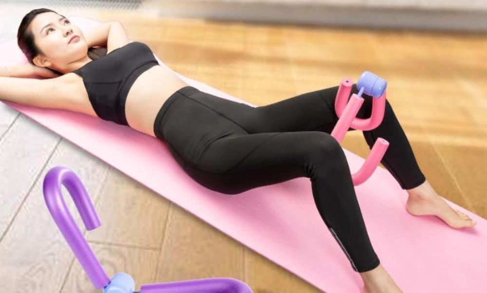 Person using a pink exercise device on a wooden floor